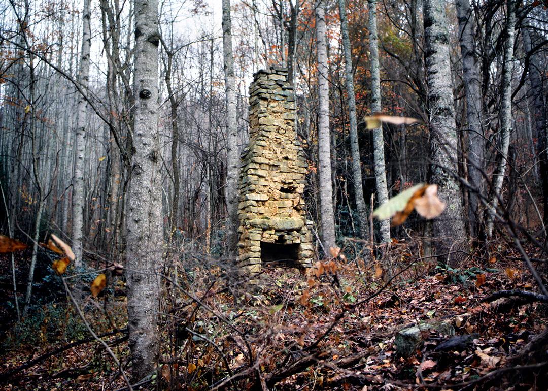 A stone chimney is seen from a 19th century log cabin located in the Appalachian Mountains in Northern America.