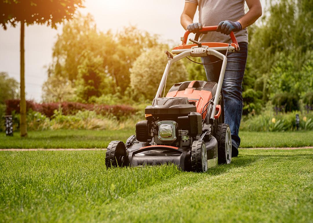 A gardener moving the lawn grass before making a landscape design.