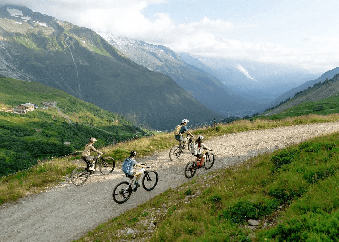 A group of e-mountain bikers riding through glacial mountains.