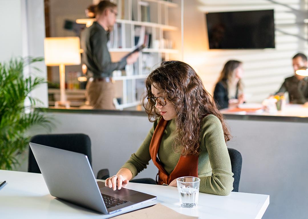 A young female entrepreneur working quietly in a modern office space.