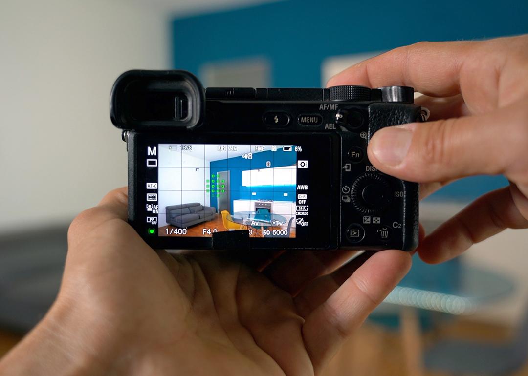 Person professionally taking a photograph of a home's interior.
