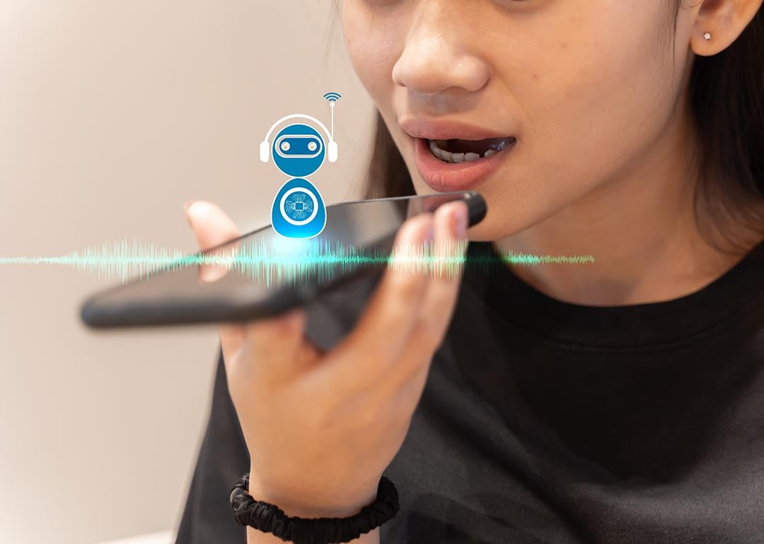 A young woman talking into a smartphone with AI voice assistance.