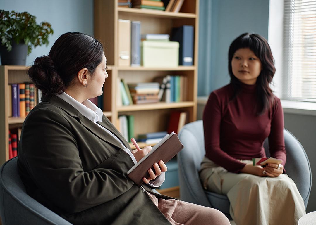 An Asian teenage girl in a counseling session with a female therapist.