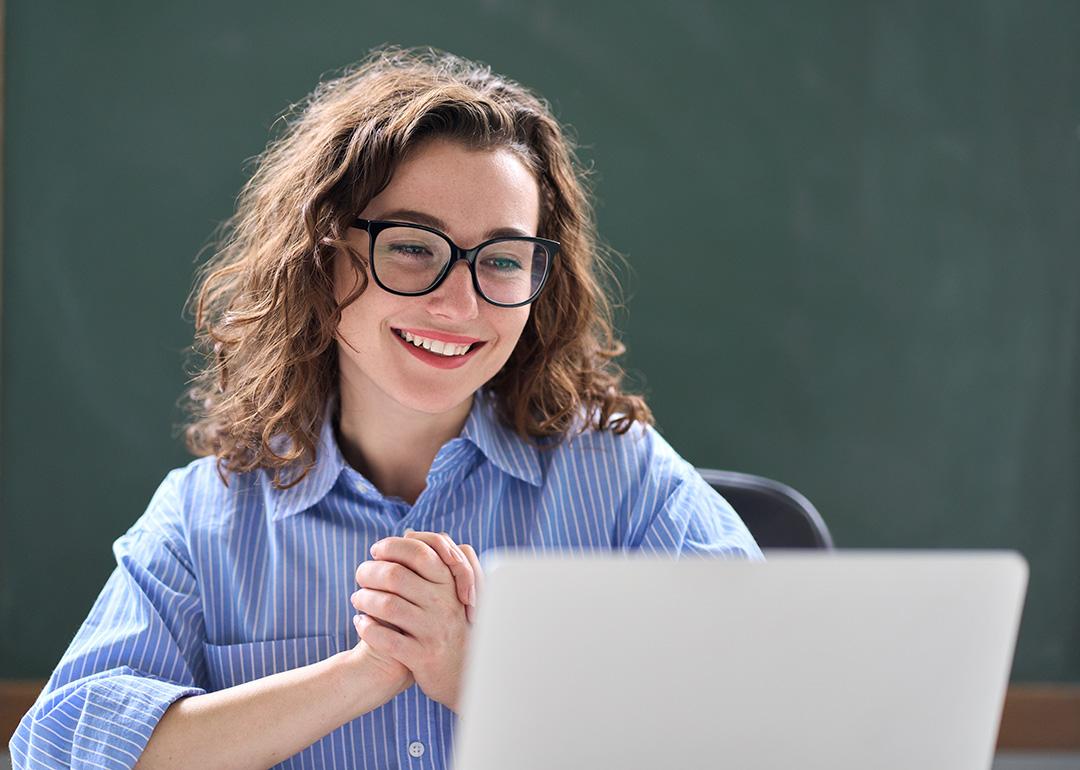 A teacher looking excited while reading good news online.