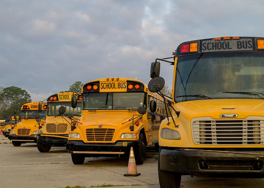 A row of school buses parked at a lot.