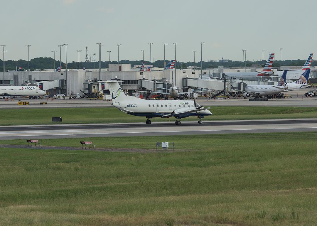 Airplanes are landing and taking off at the runway at the Charlotte Douglas International Airport with the city of Charlotte, North Carolina.