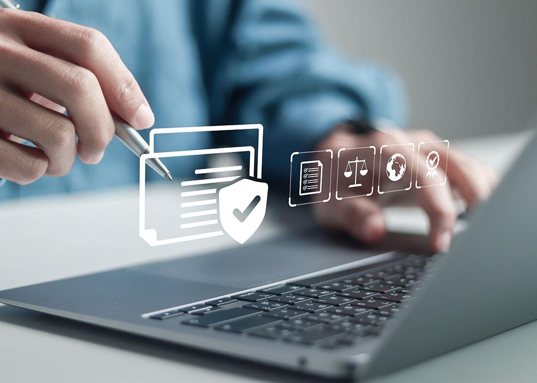 Businessman using a laptop illustrated with compliance software graphics.