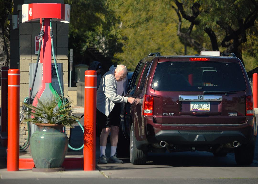 A senior citizen pumping gas into his car at a Safeway filling station in Chandler, Arizona, USA.