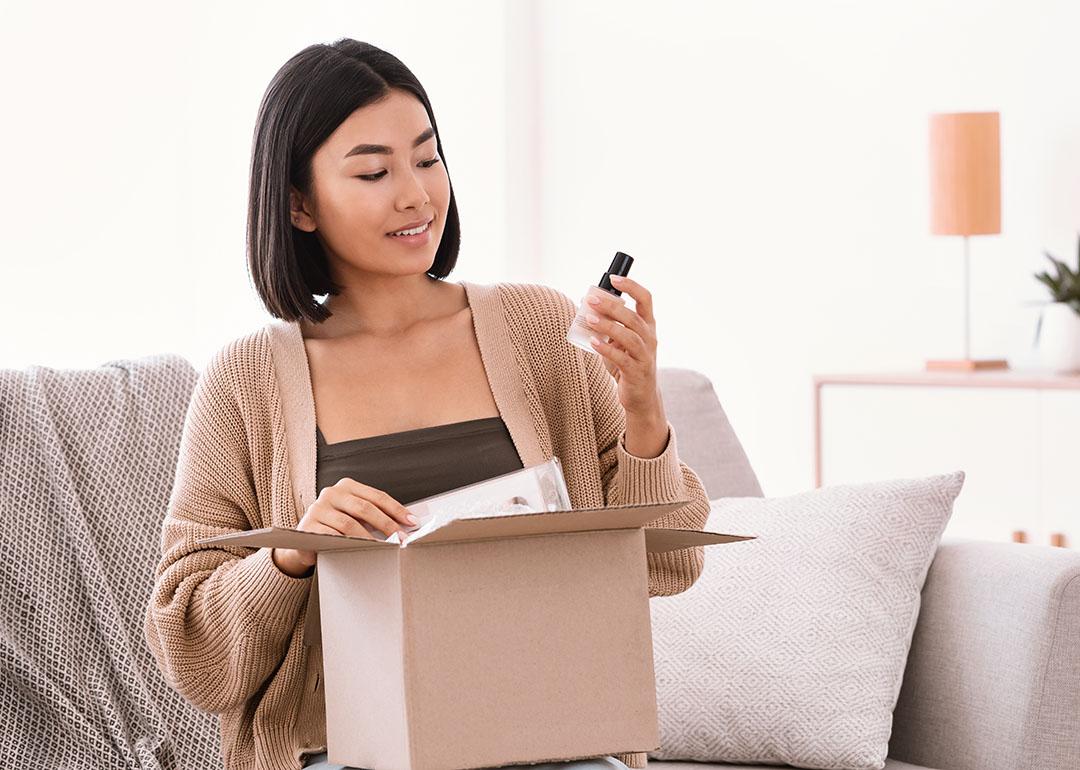 A young woman unboxing a package of makeup delivery.