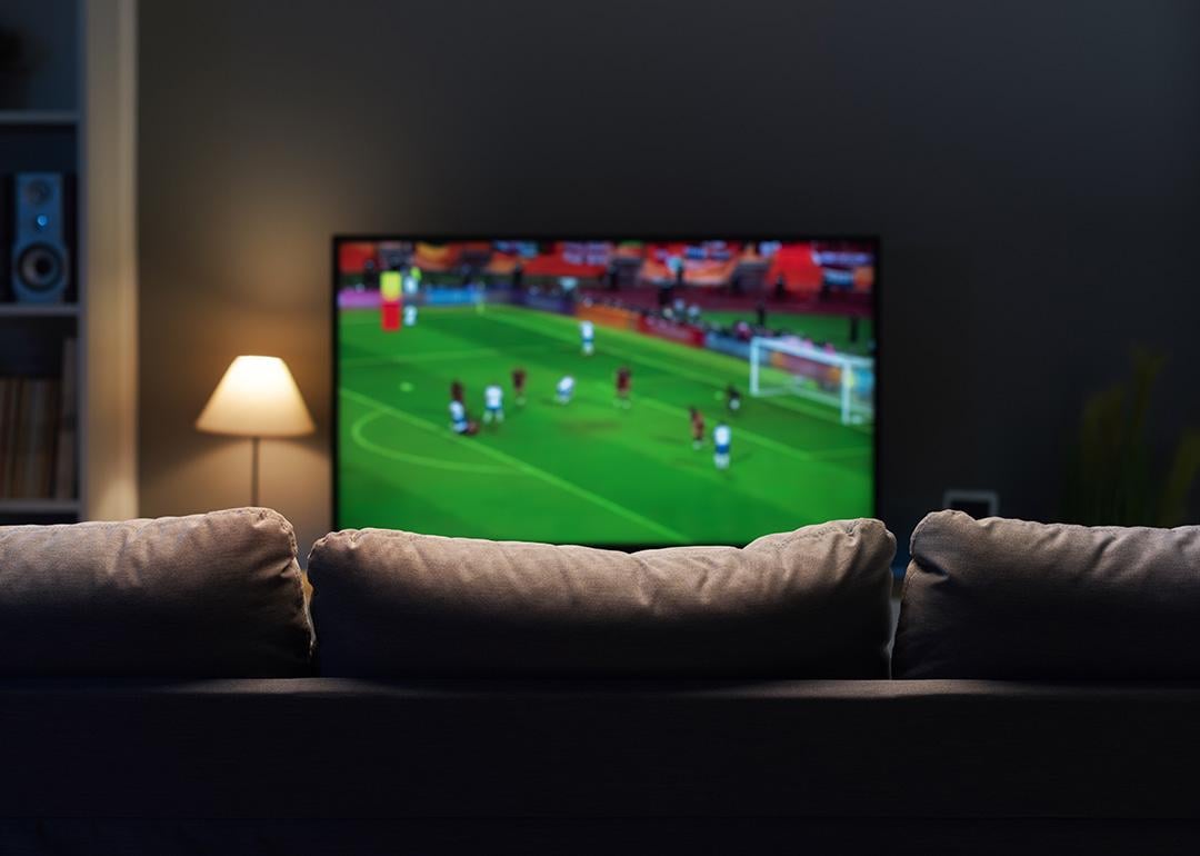 A football match displayed from a smart TV at a home's living room.