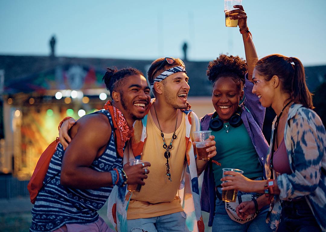 Friends enjoying and vibing to outdoors music during a summer music festival.