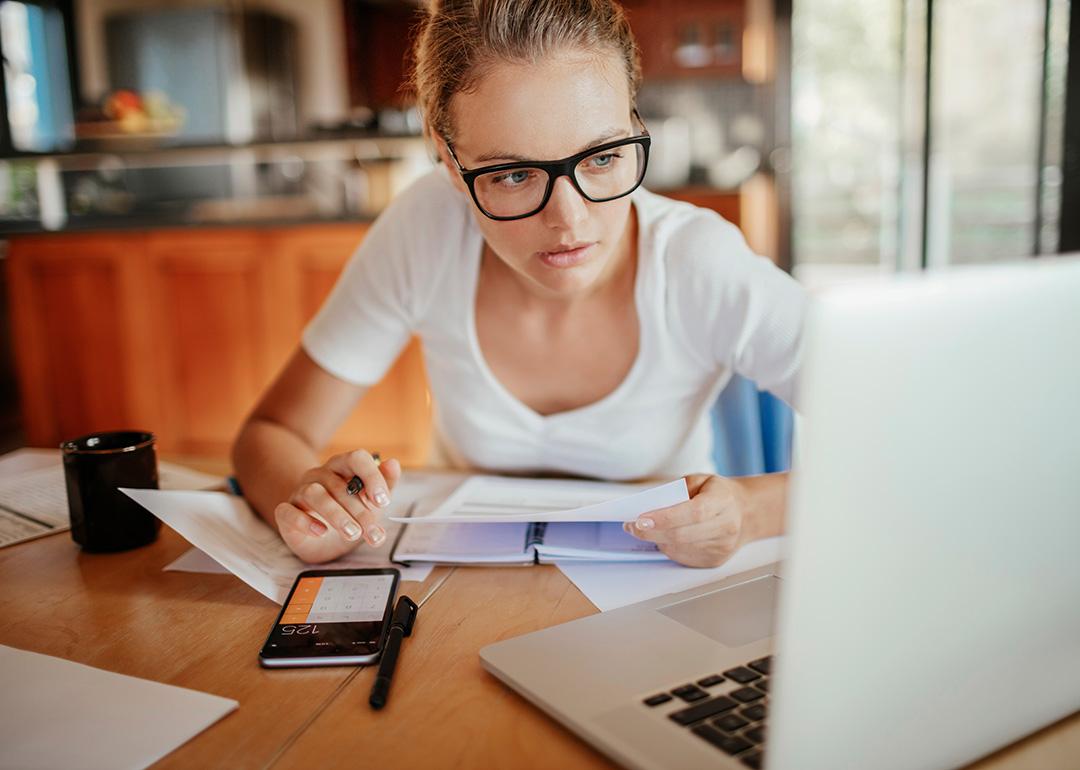 A young adult reviewing her property's documents from her laptop at home.