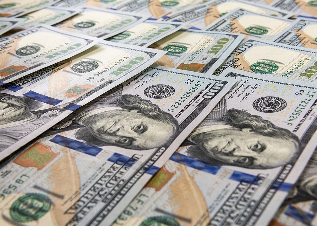 U.S. hundred dollar bills laid flat as a background. 