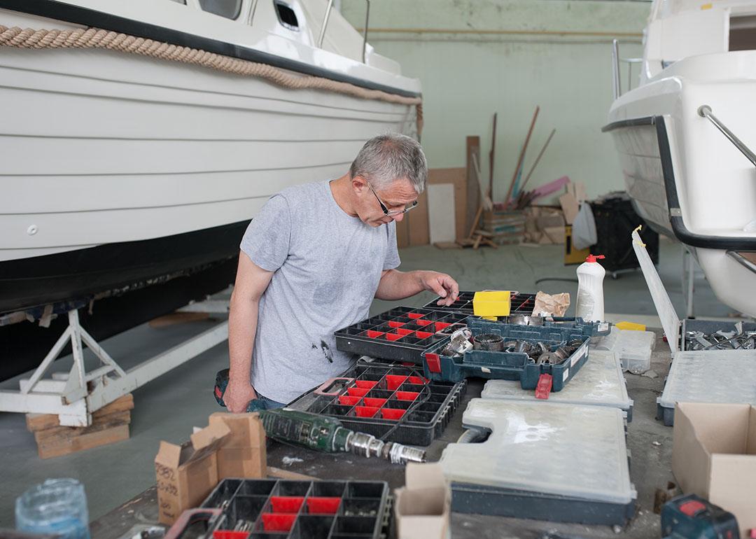 A person looking for an item on a tool box set for a boat repair. 