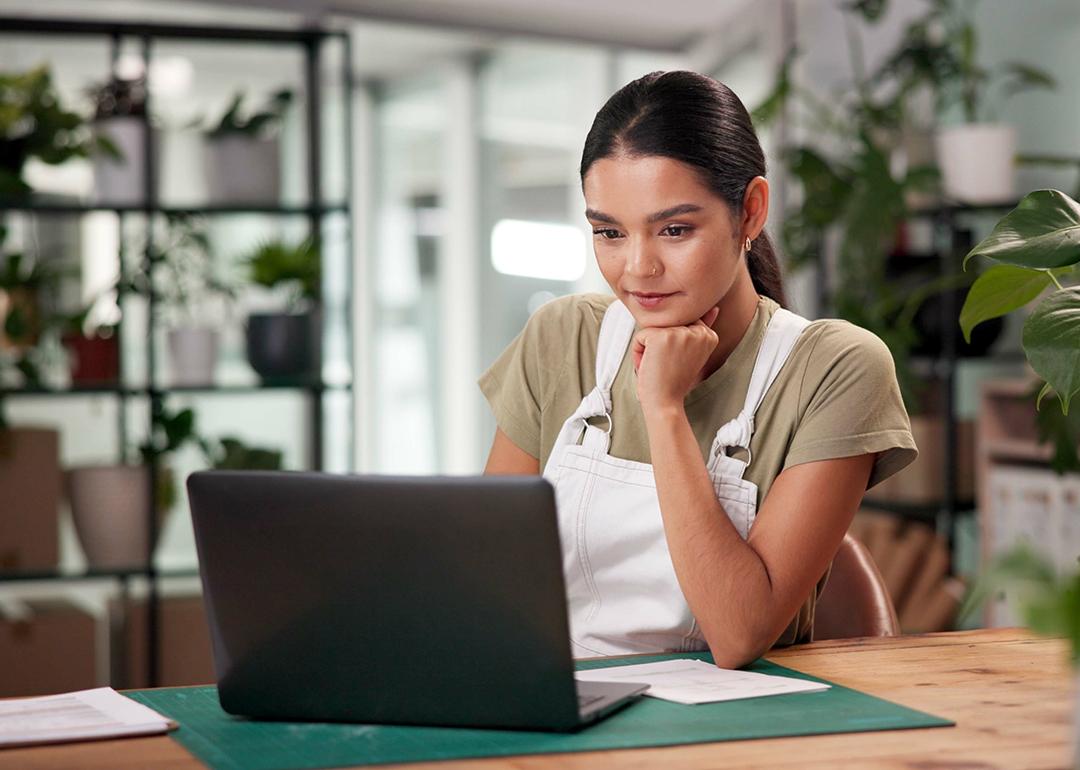 A female small business owner using a laptop to review files.