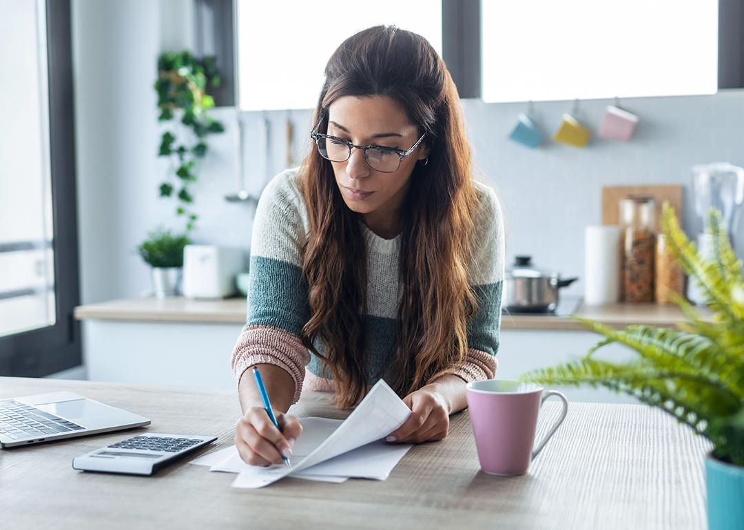 A woman reviewing finance documents at home.