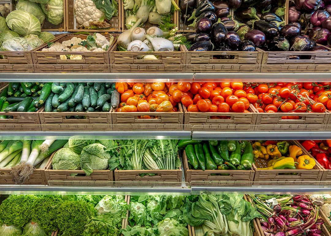 Various kinds of vegetables displayed on boxes in a greengrocer's shop.