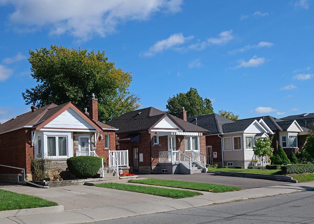A row of detached bungalow-style brick homes in a street.
