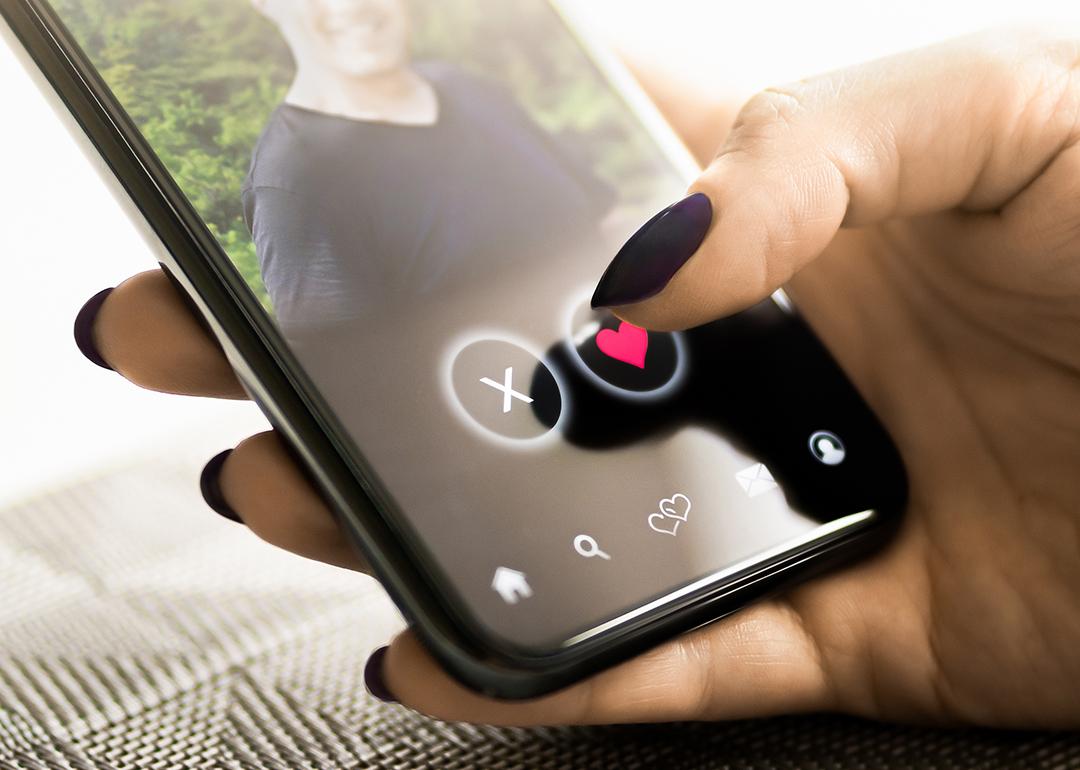 A person checking a profile of another person from a dating application in her smartphone.