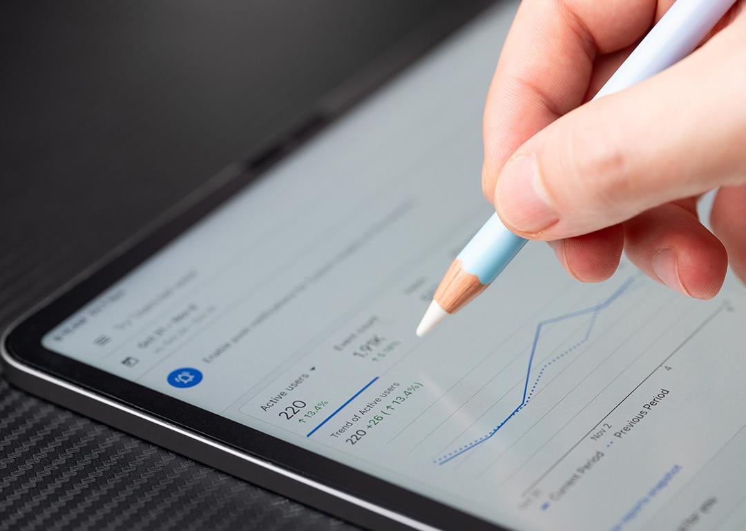 Person navigating Google Ads analytics dashboard on a tablet.