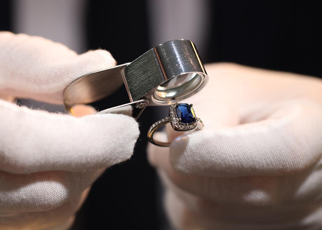 A jewelry appraiser using a loupe to evaluate a bejeweled ring.