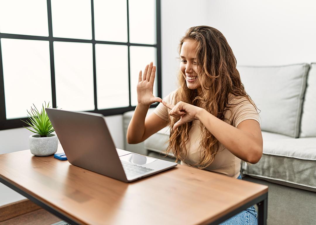 A person communicating through sign language during a Zoom video call.