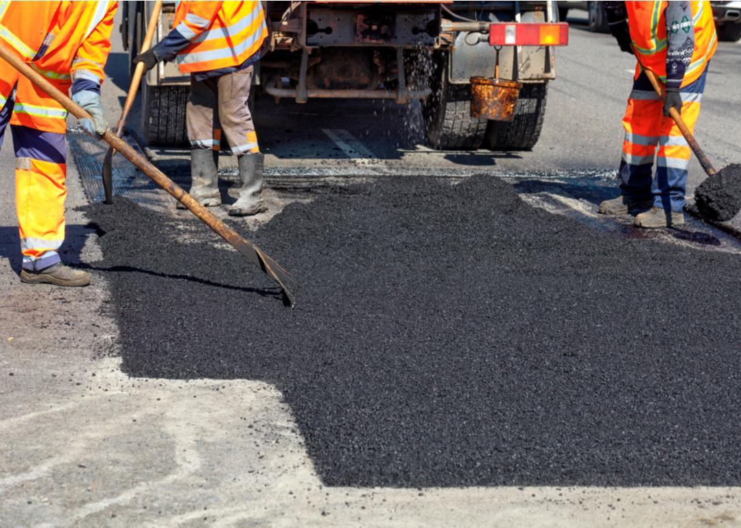 Road workers repairing a srteet with new hot asphalt