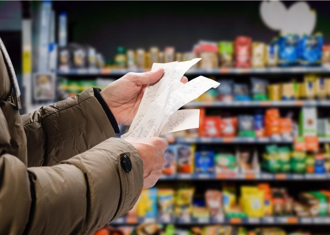 A person reviewing their receipt in the supermarket to track prices