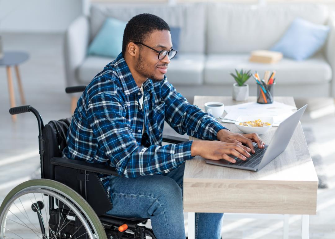 Man in wheelchair using laptop.