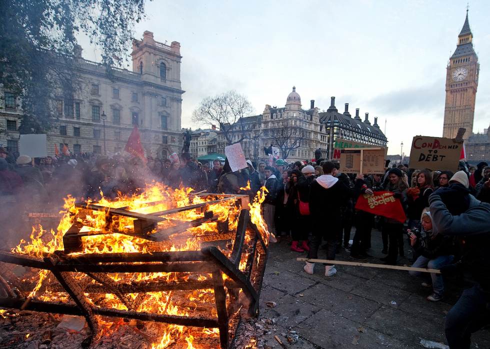 Protestors gather around a large bonfire in London. 