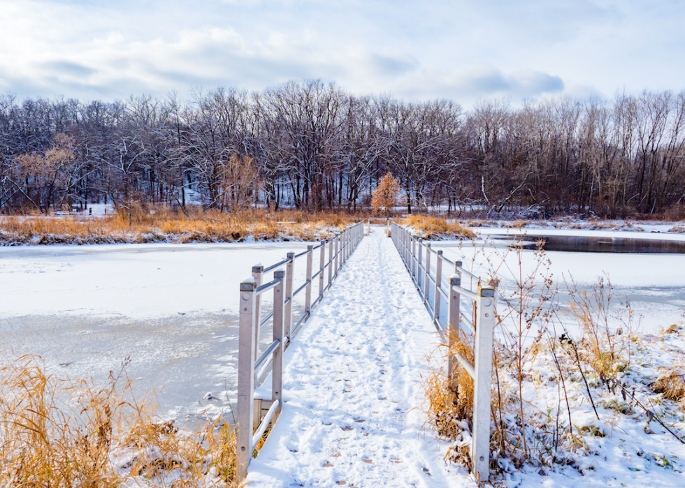 A snowy nature path over a frozen lake.