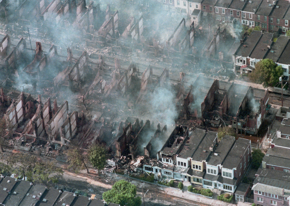 Aerial view of smoke rising from smoldering rubble where some 60 homes were destroyed by fire after a shootout and bombing at the back-to-nature terrorist group MOVE's house in West Philadelphia May 14, 1985.