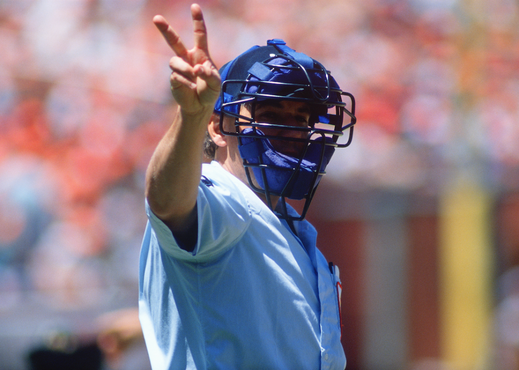 A baseball umpire holds up two fingers.