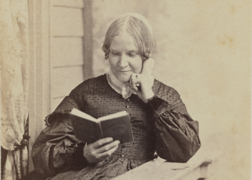 Lydia Maria Child posed reading a book.