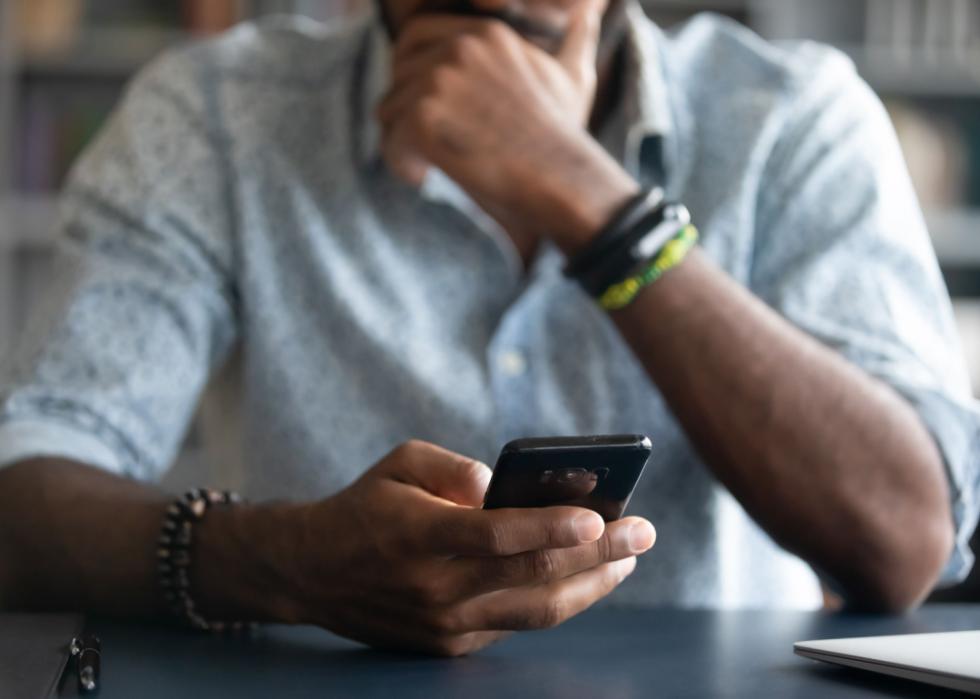 Man holding cell phone close up.