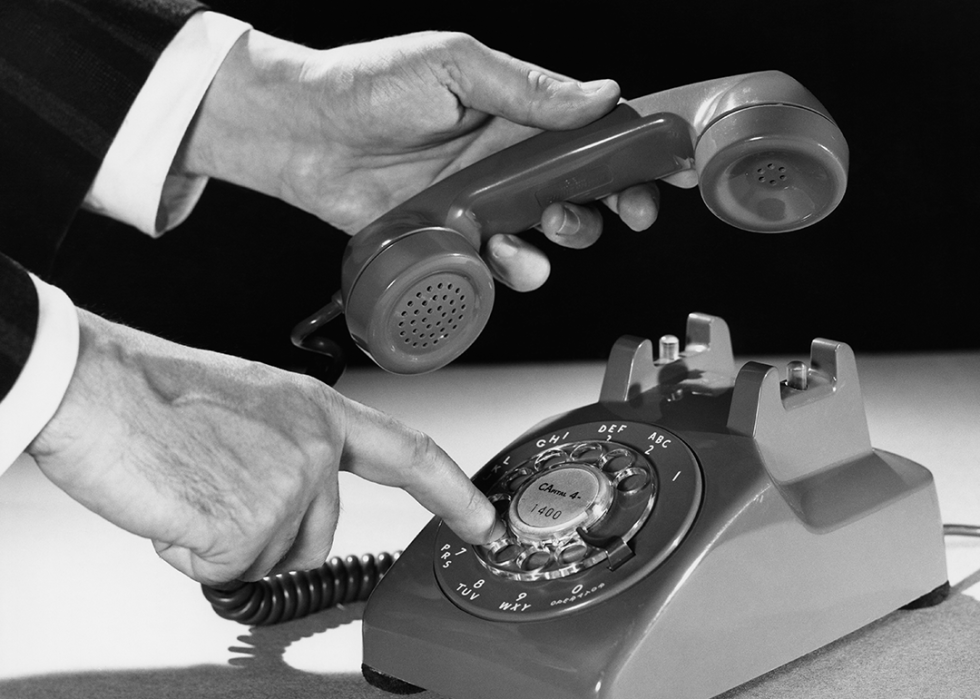 Hand dialing number on a rotary telephone.