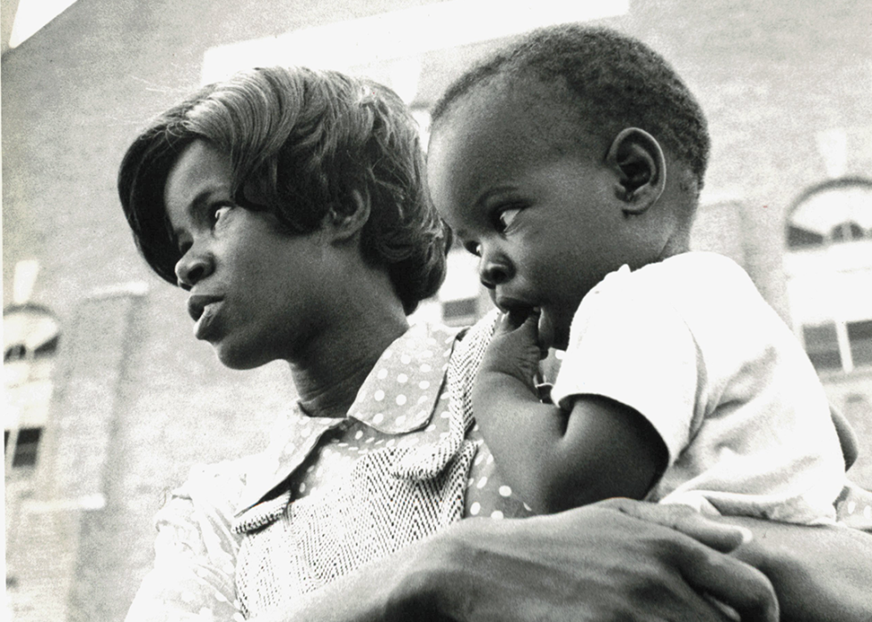 A mother and child watch the Unity March at a Juneteenth celebration.