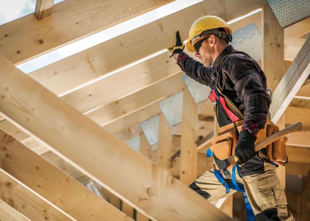 Construction worker building house frame.