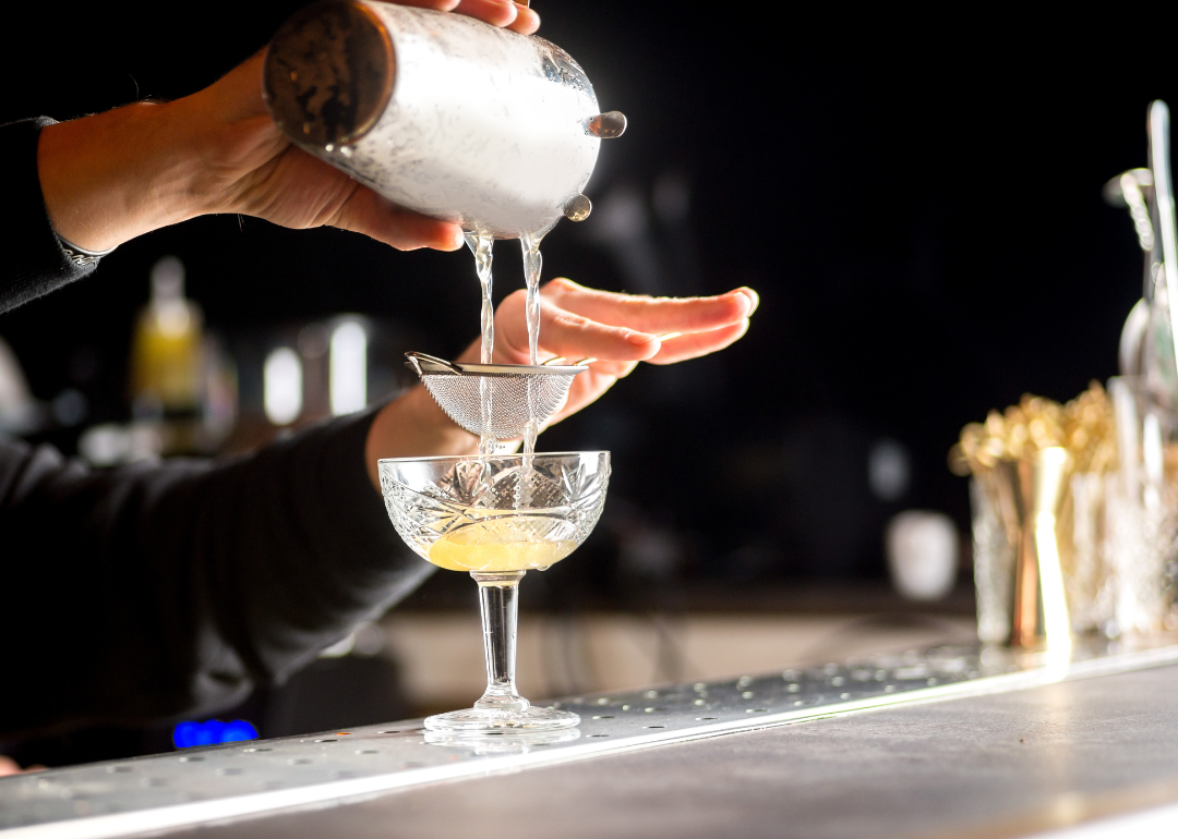 Bartender pouring cocktail.