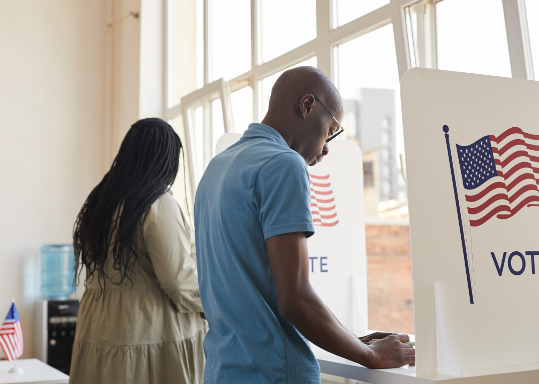 People fill out ballots in voting booth