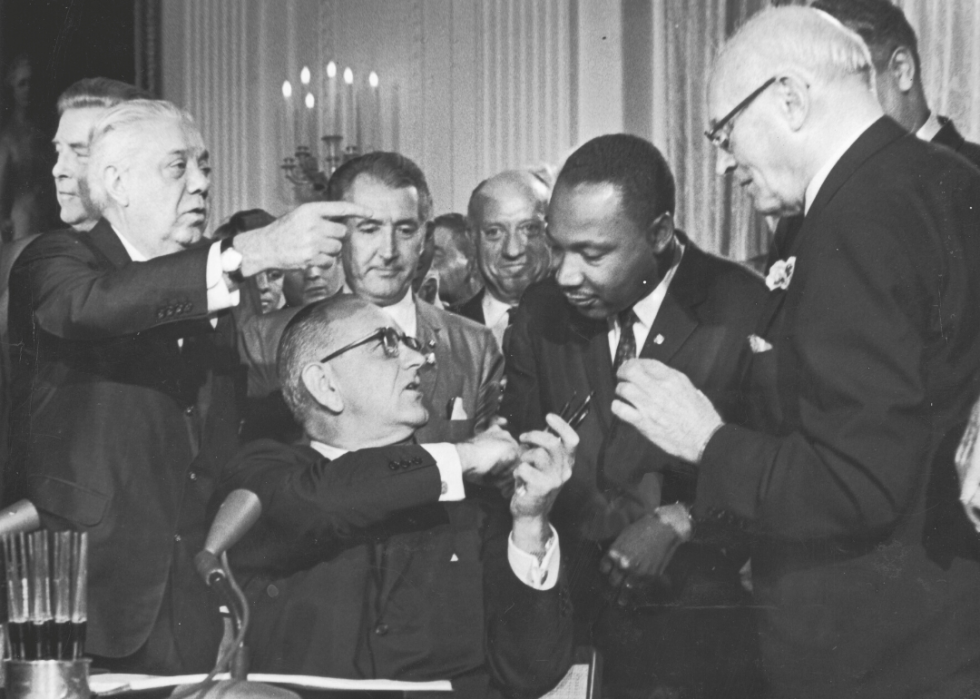 President Johnson shakes Martin Luther King Jr hand at Civil Rights Act signing.
