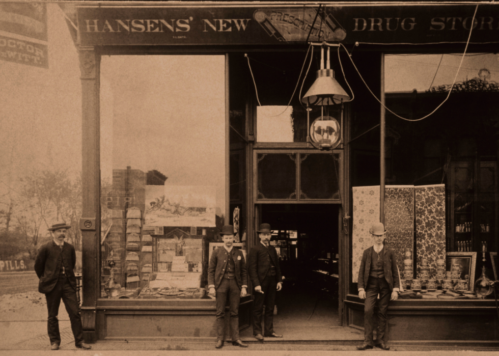 Four men standing in front of drug store.