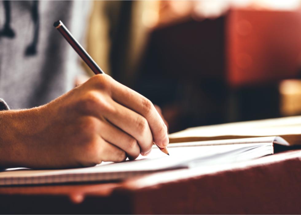 Close up view of hand writing in notebook.