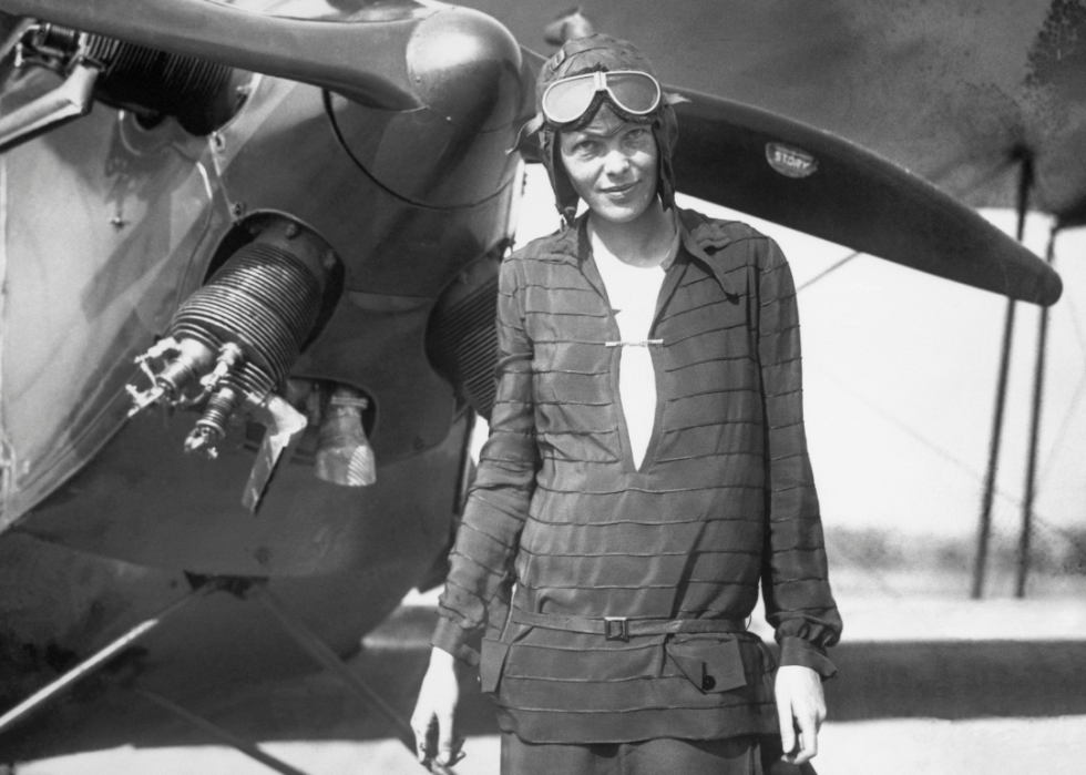 Amelia Earhart stands with plane