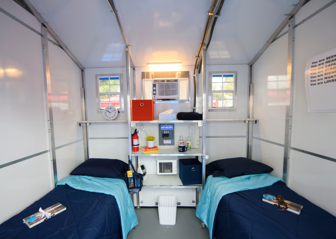 View inside a prefabricated tiny house with two beds designed as temporary housing for homeless