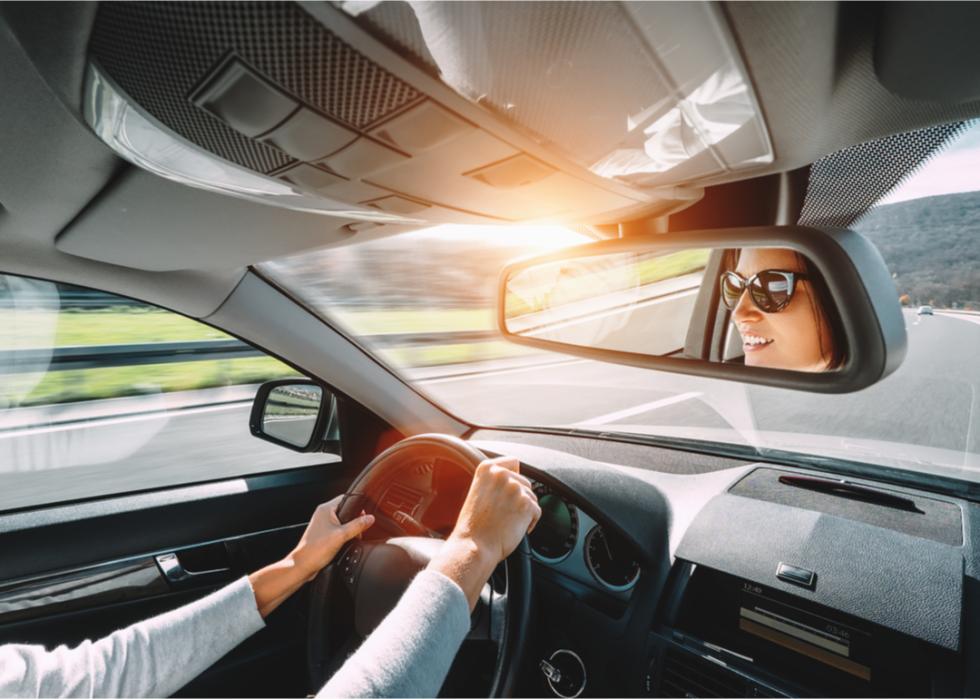 A woman's face is seen in the rear view mirror of a car as she drives.