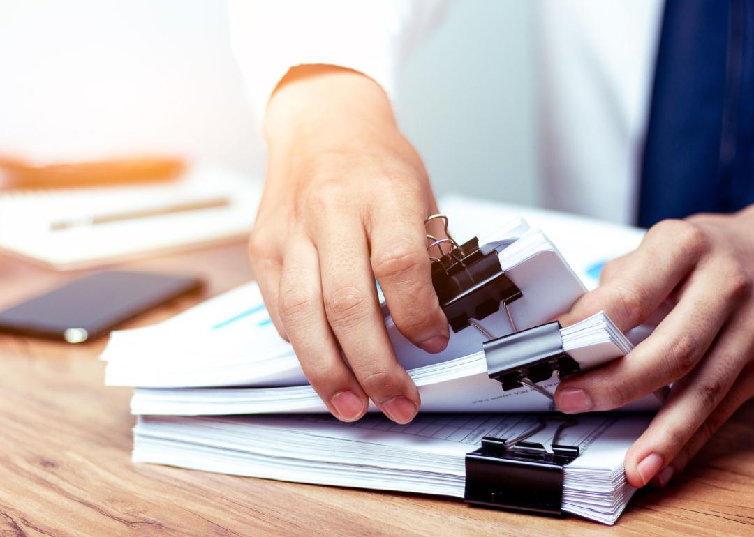 Person sorting through stacks of documents