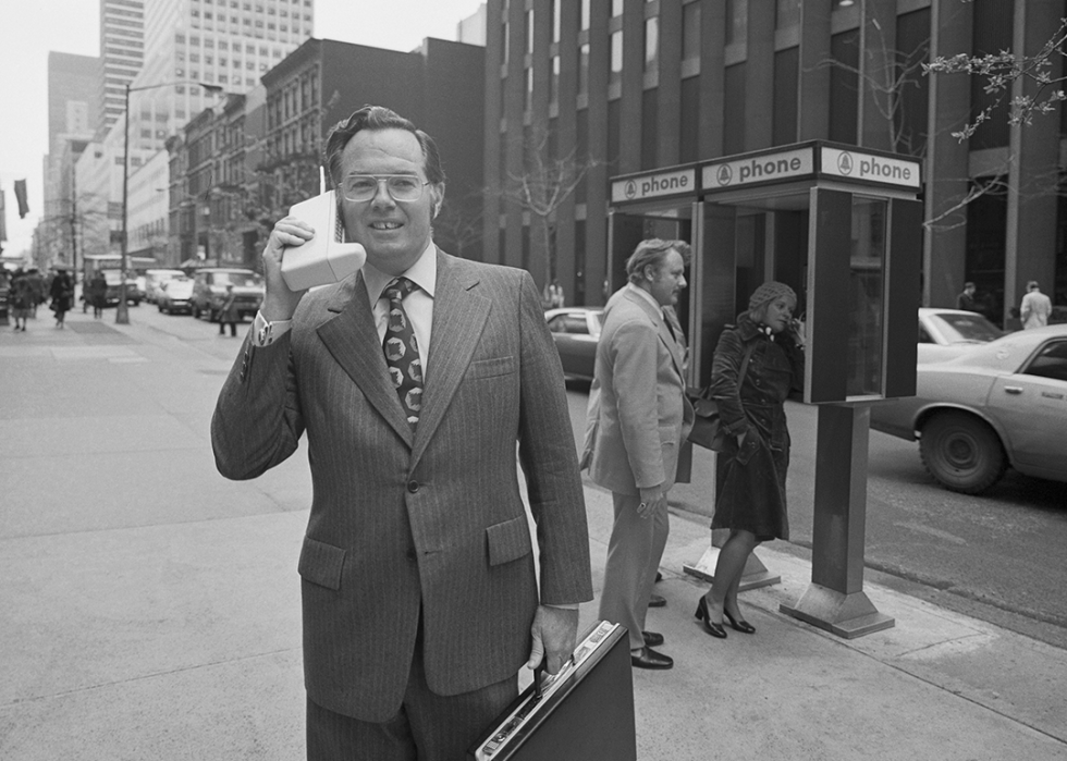 Motorola vice president John F. Mitchell holds a Dyna T-A-C portable telephone.