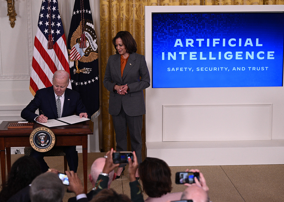 US Vice President Kamala Harris looks on as US President Joe Biden signs an executive order.