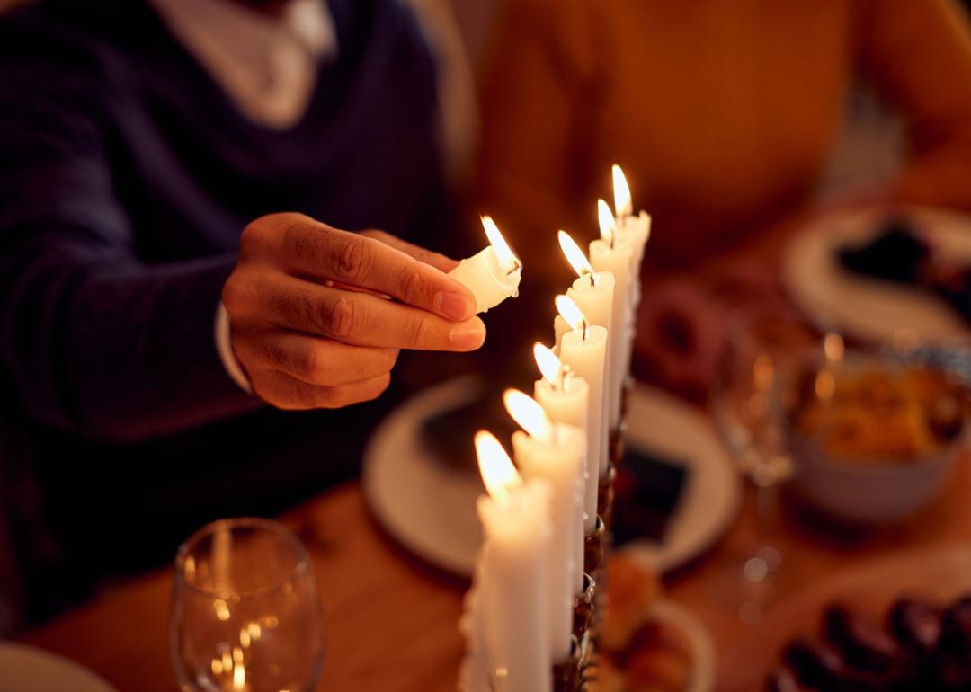 Man lightning a menorah during family dinner.